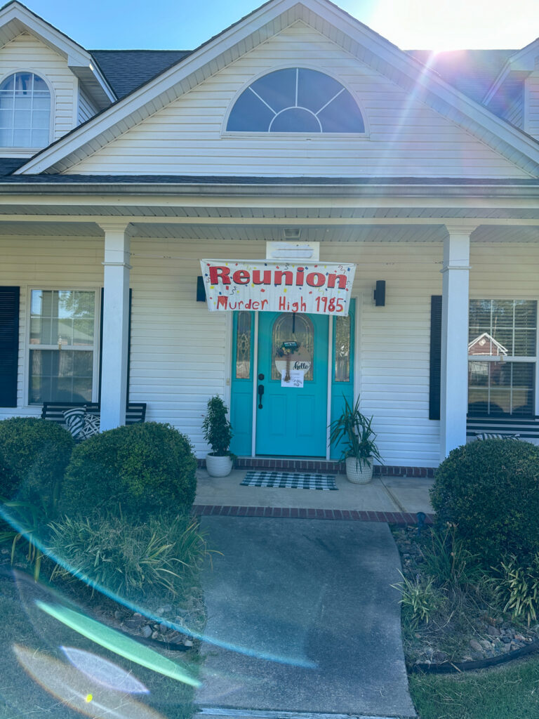 Murder High Class reunion sign hanging on porch