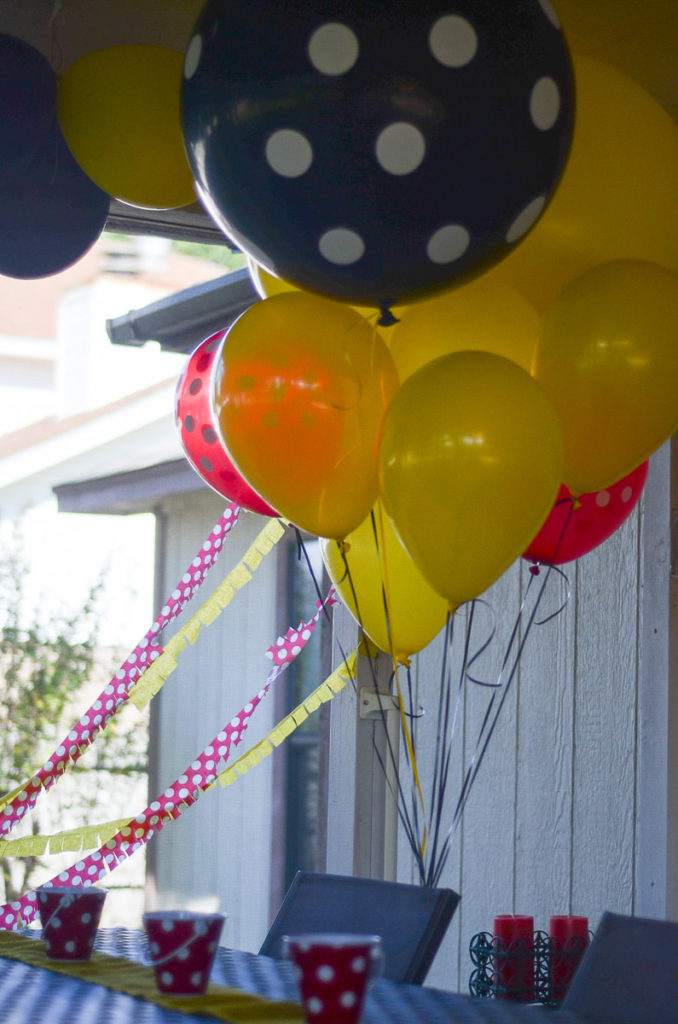clusters of yellow and black balloons above table