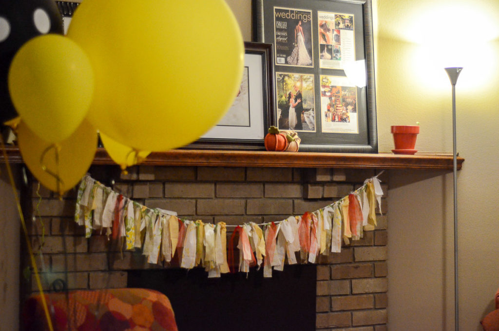 mantle dressed up with ribbon garland and yellow balloons