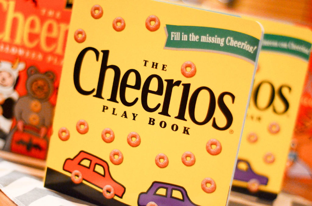 group of Cheerios Play Book favors standing on table for 1st birthday party ideas