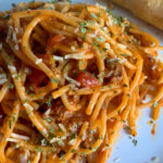 one pot spaghetti on white plate with ideas to make jarred spaghetti sauce better