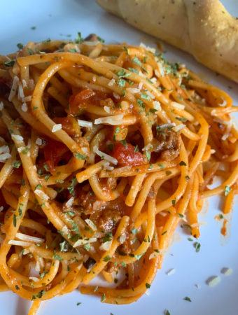 one pot spaghetti on white plate with ideas to make jarred spaghetti sauce better