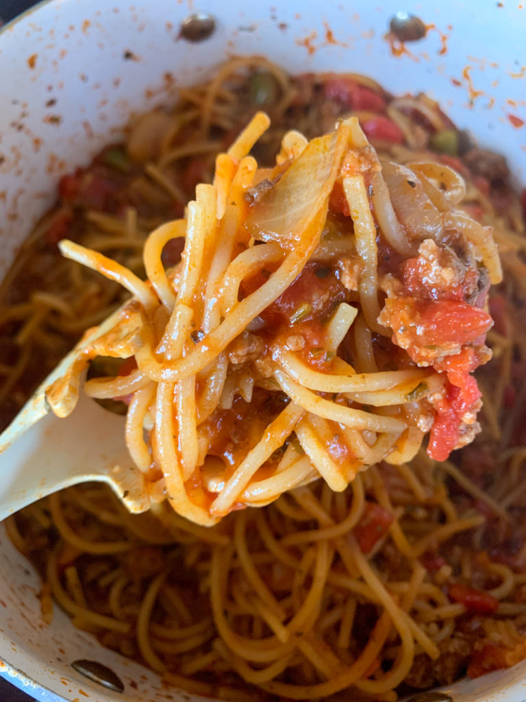 spoonful of one pot spaghetti over pot