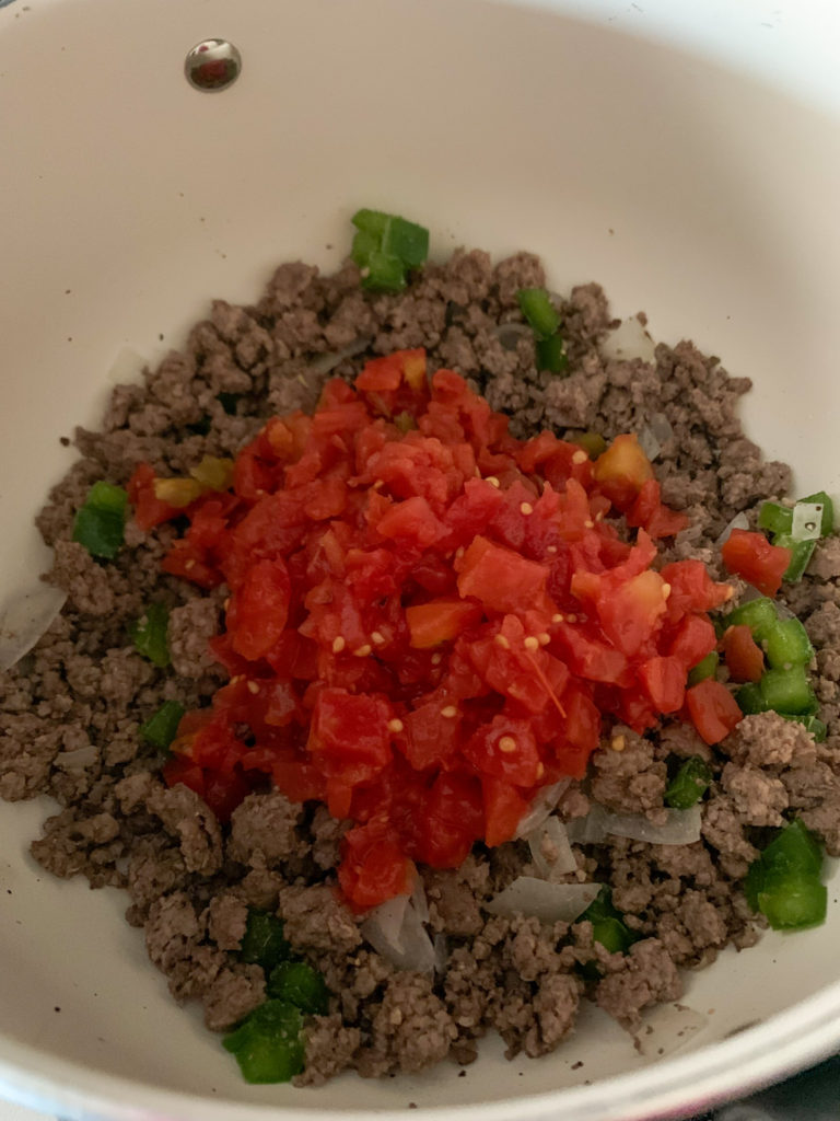 ground beef, tomatoes and seasonings in dutch oven