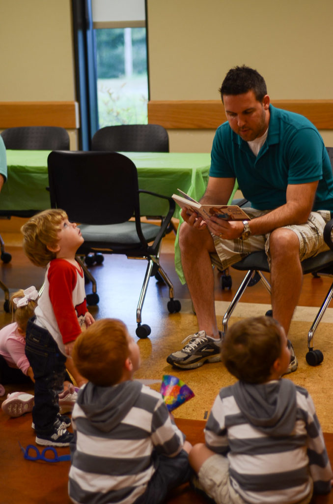 man reads to small children during library story time 