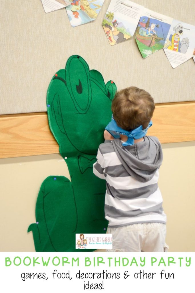 little boy plays pin the tail on the bookworm