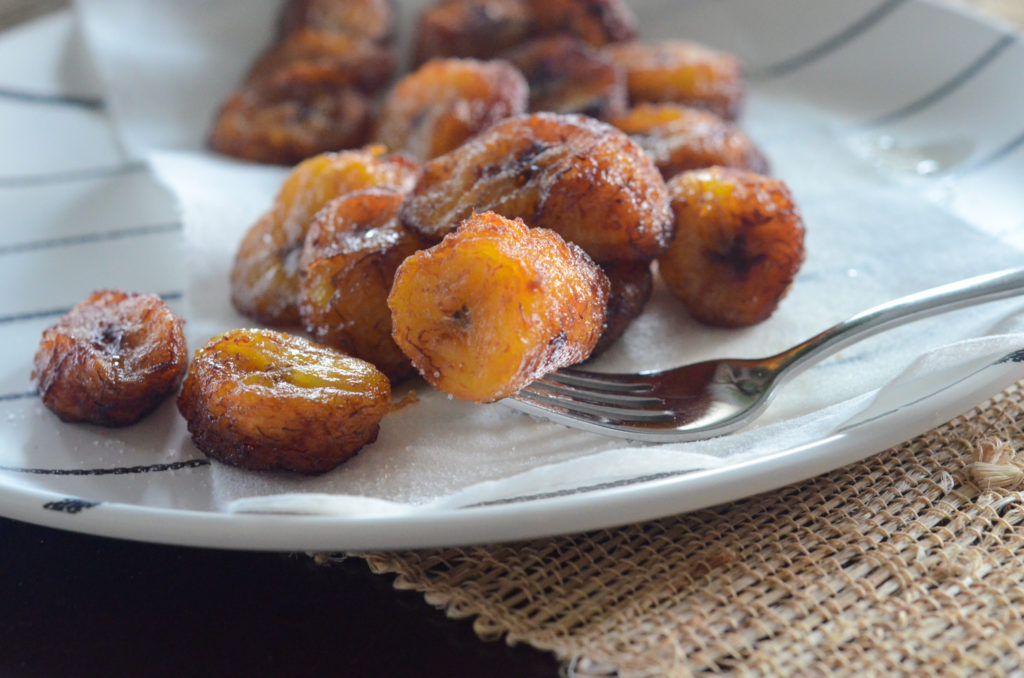 fried plantains on white plate with silver fork