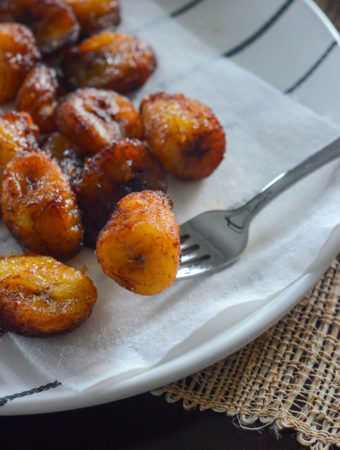 Platanos Maduros - fried plantains of Panama - on a white plate with a napkin and fork