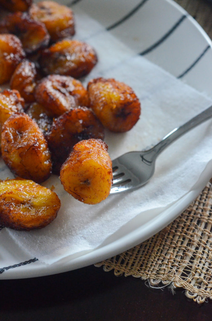 Platanos Maduros - fried plantains of Panama - on a white plate with a napkin and fork