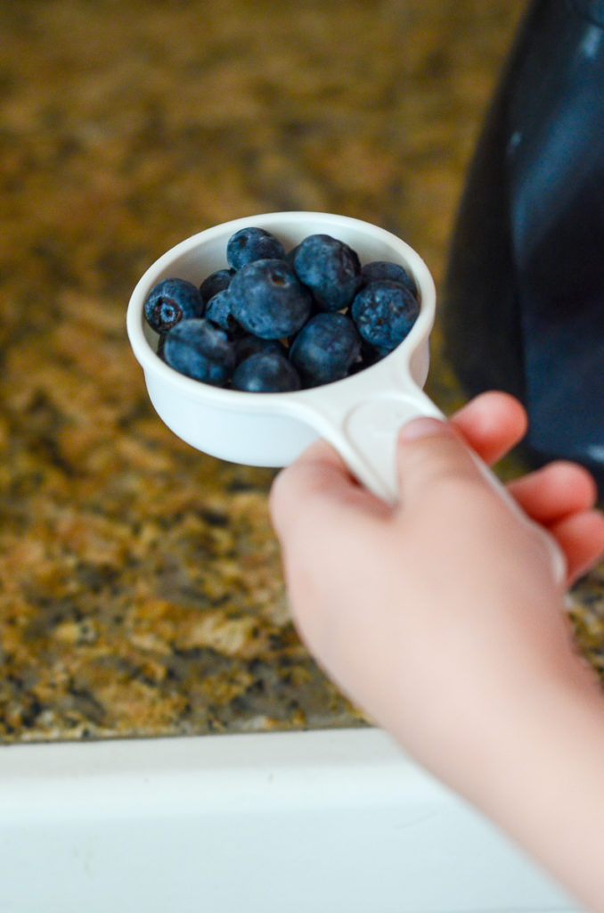 cup of blueberries in little girl's hand