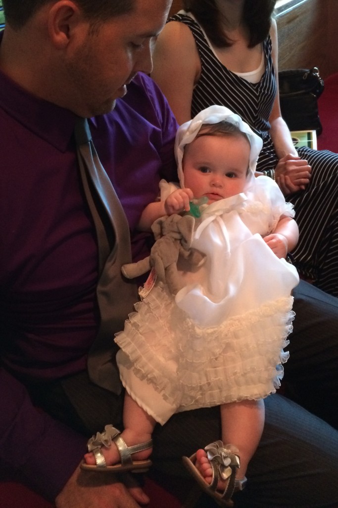 dad holds baby in custom christening gown at baptism