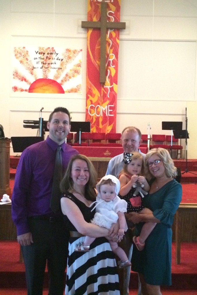 family with baby in custom christening gown at church