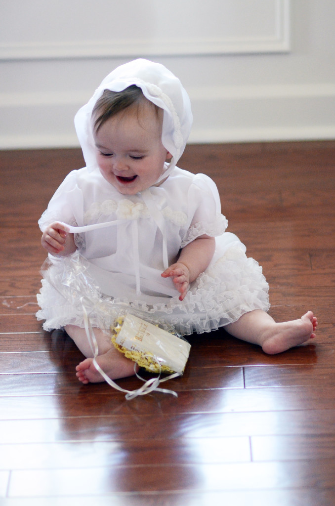 baby smiles while playing in her custom christening gown from mom's wedding dress