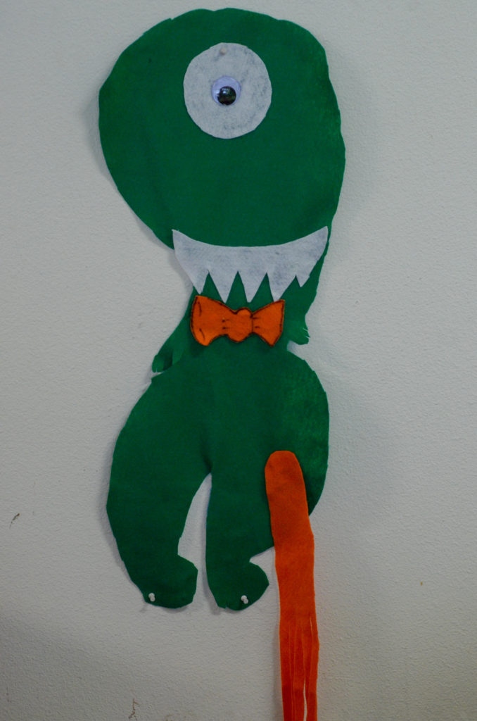 pin the tail on the monster game on wall at monster party