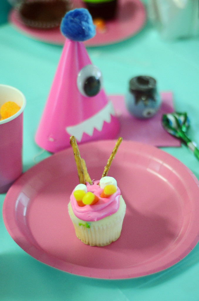 place setting with monster cupcake and pink monster party hat at little monster birthday party