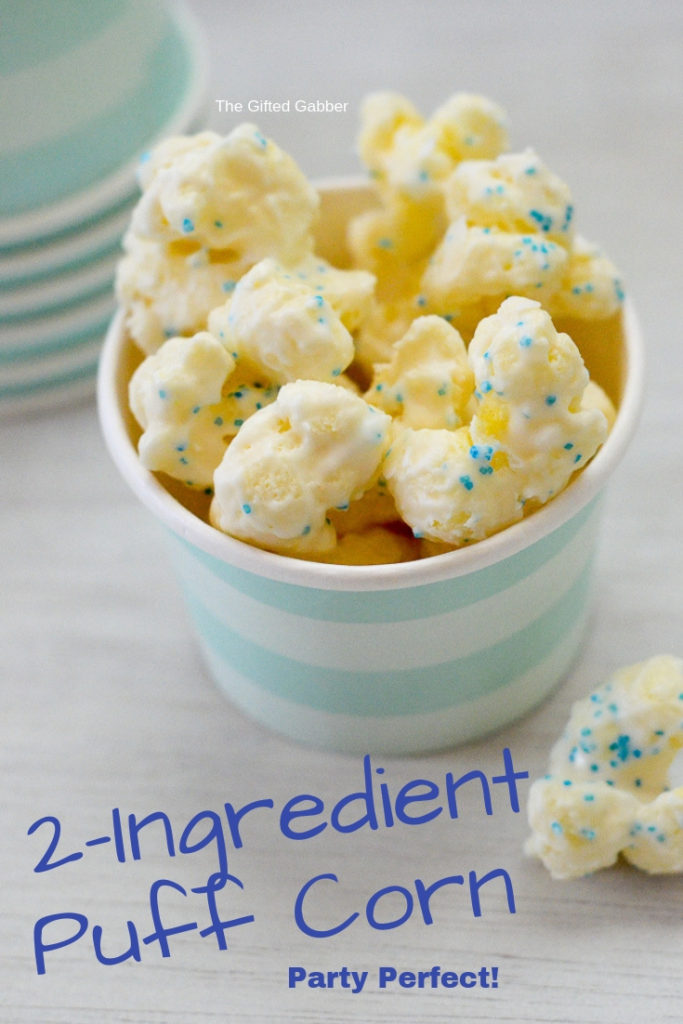 white chocolate puffed popcorn in a blue striped cup with text overlay 