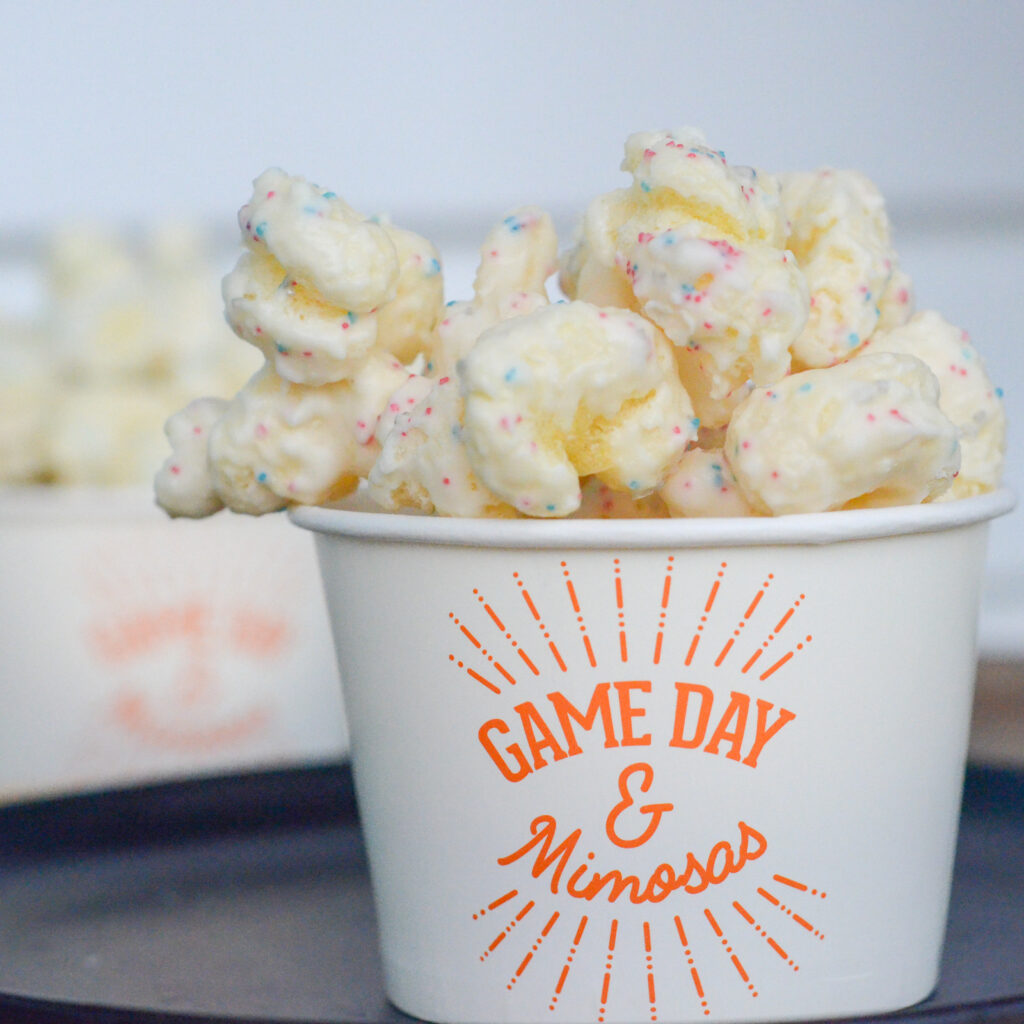 almond bark Puffcorn with sprinkles (white chocolate popcorn) in a Game Day and Mimosas cup