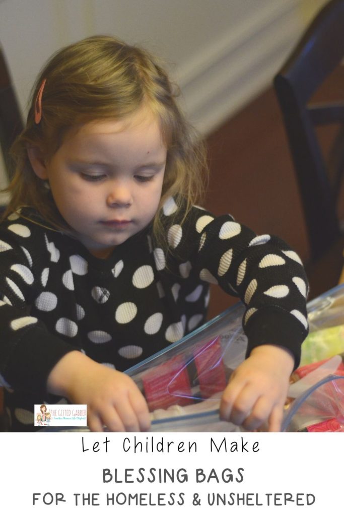 little girl puts hygiene kit supplies in blessing bags for homeless residents