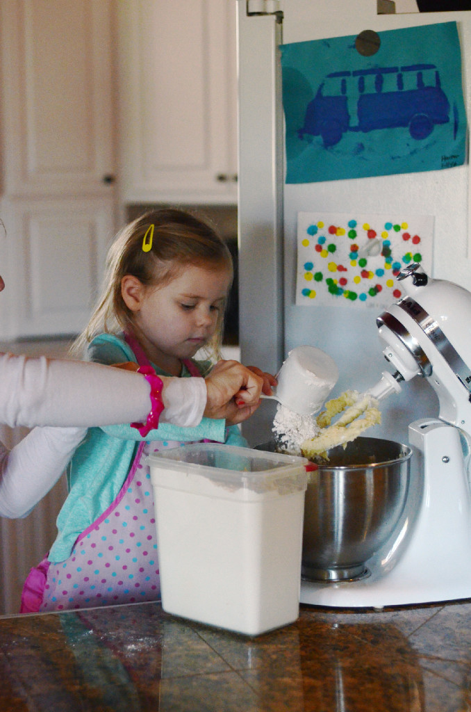 mom and daughter mixing dough in mixer 