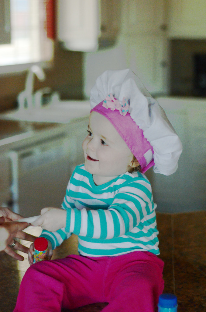 baby on kitchen counter with chef hat