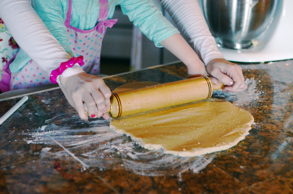 mom and daughter rolling dough on counter