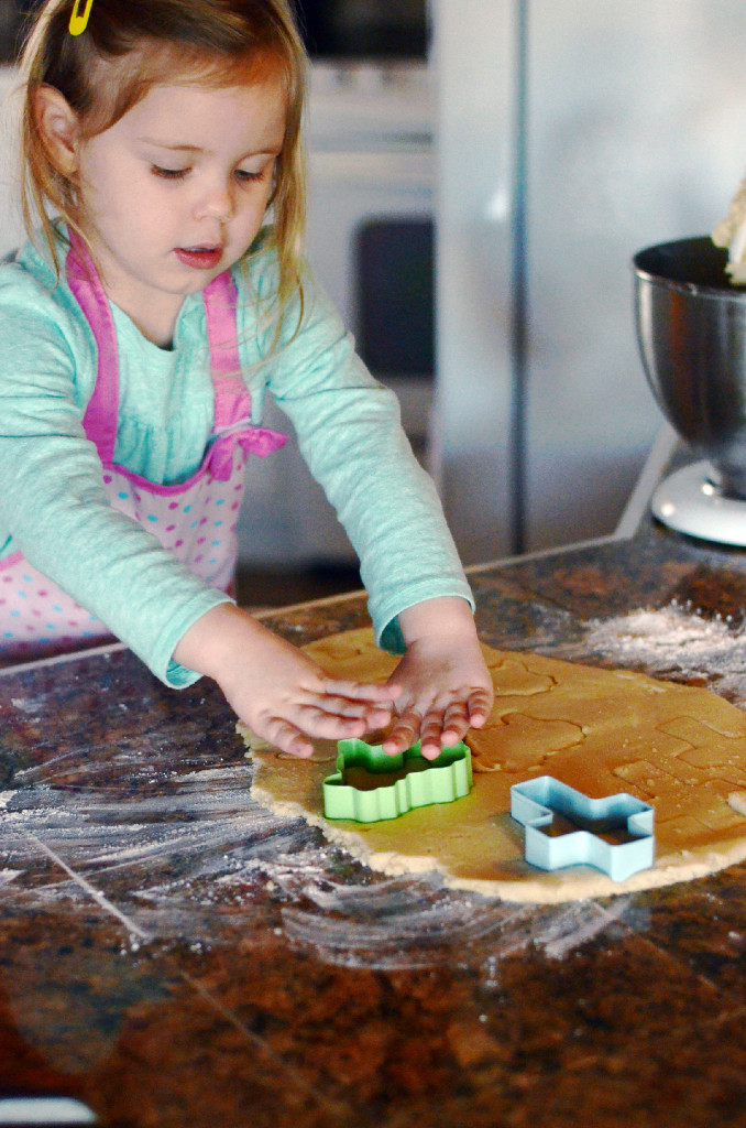 little girl using lamb cookie cutters for Easter lamb cookies