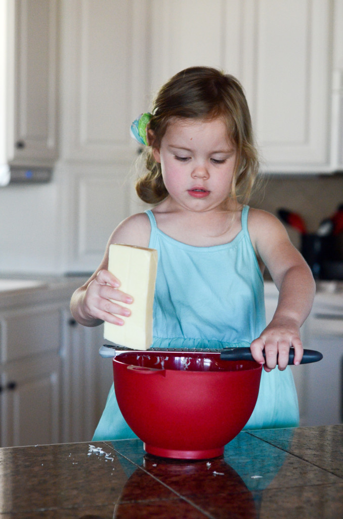 little girl grates cheese for Tex Mex breakfast dish