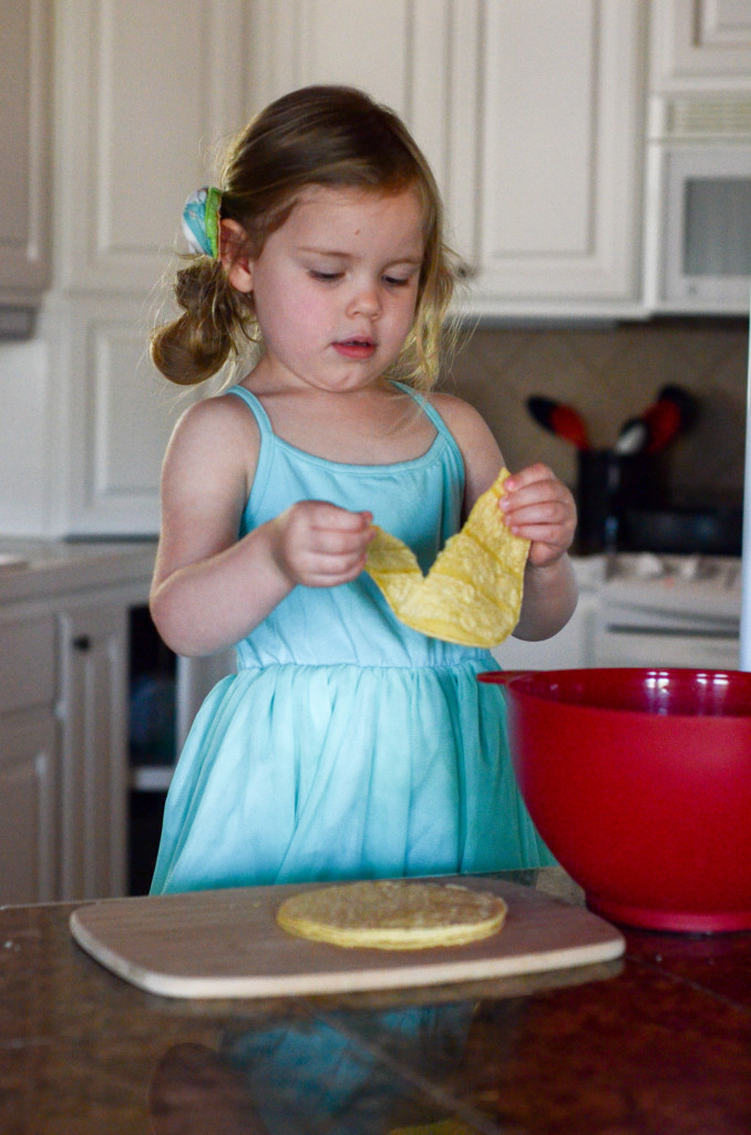 little girl helps tear tortillas for Tex Mex Migas  for a Tex Mex breakfast skillet