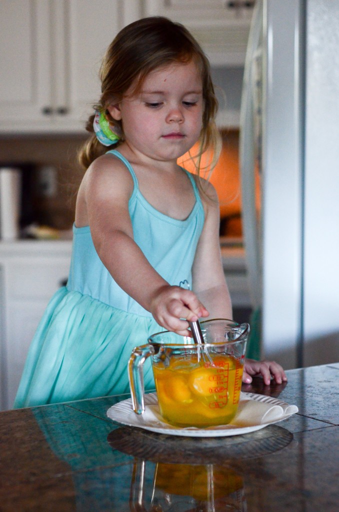 little girl whisks eggs in glass mixing bowl for a scrambled eggs and tortillas breakfast recipe