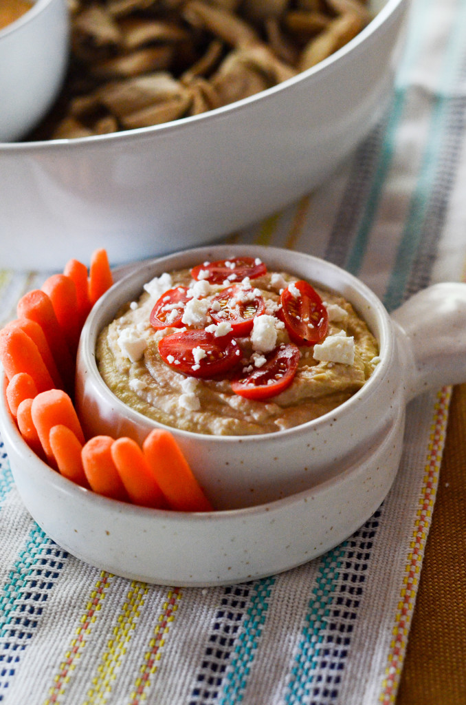 classic hummus in a white dip bowl with carrots
