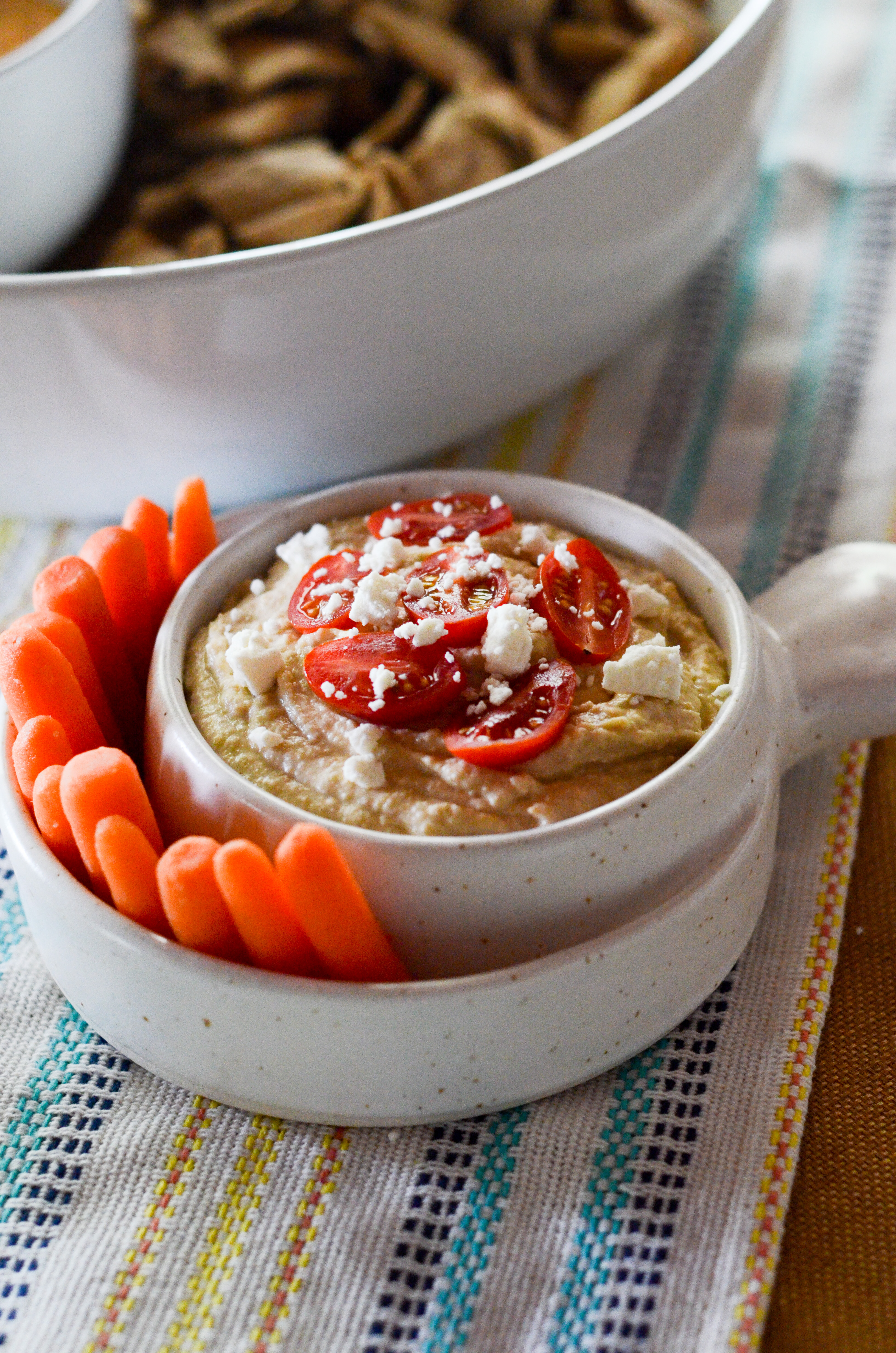 lebanese hummus in white dip bowl with carrots