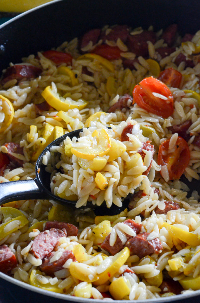 This easy summer squash and sausage skillet can actually be made as two separate recipes - one using orzo pasta and one only using the yellow squash and sausage. Without the orzo, this is a one-pan meal. With the orzo, it is a two-pan meal. This is a delicous and simple dinner! #recipes #dinner #squash #sausage #orzo