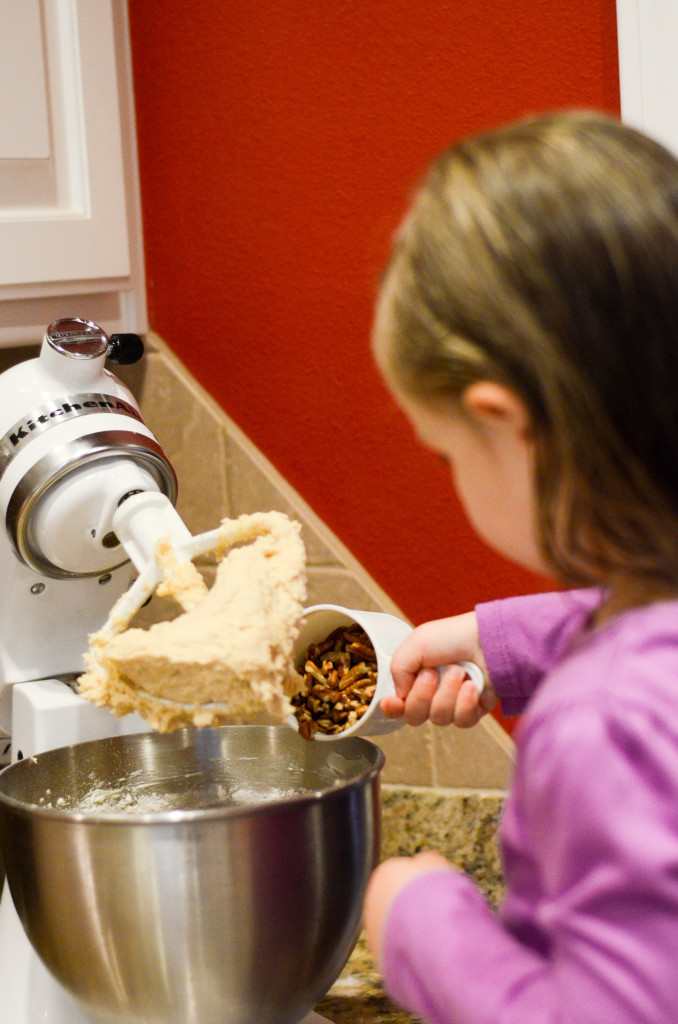 little girl making cranberry cookies in kitchen 