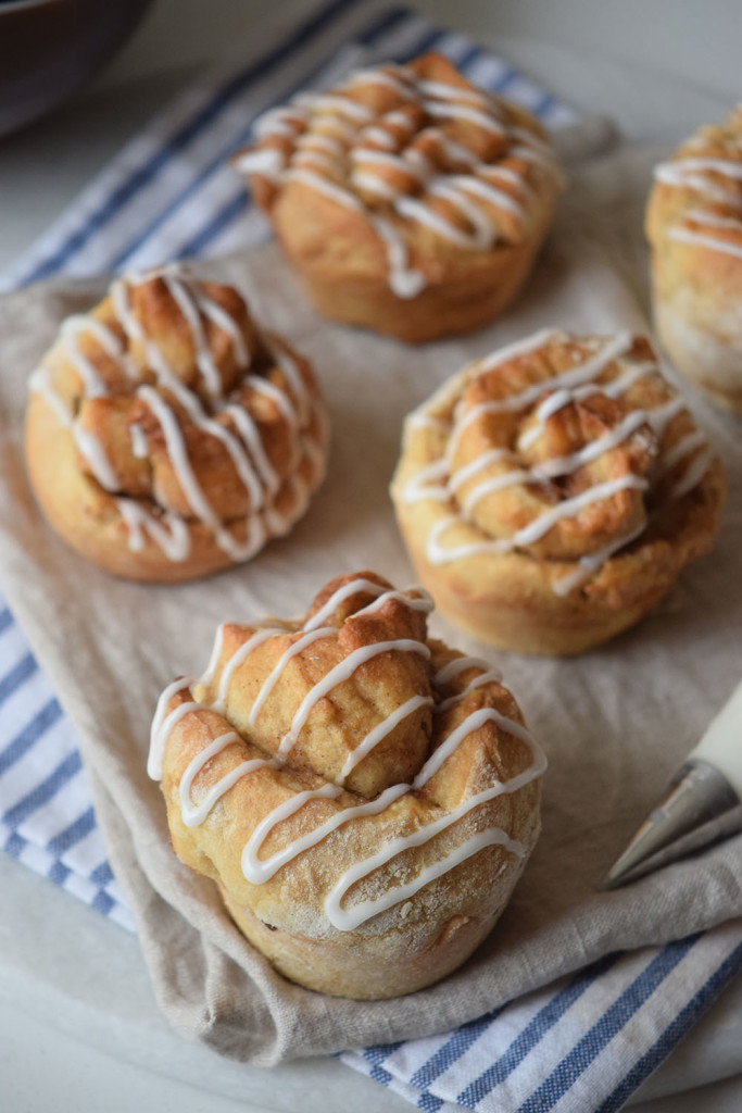 These homemade cinnamon roll muffins are an easy and fun hybrid on the standard cinnamon muffins and cinnamon rolls! This from scratch recipe can be made into mini muffins or jumbo muffins. Glaze the cream cheese icing over the top to send these muffins over the edge! 