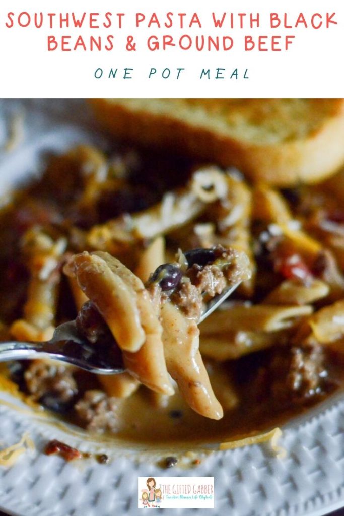 pasta with black beans in a white dish with toast 