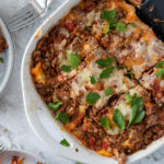 no boil lasagna with cottage cheese in white casserole dish on white background