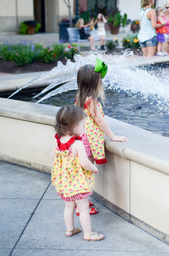 two little girls stare at the Branson Landing water fountain 
