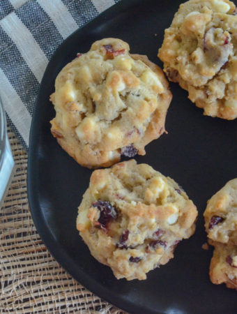 cranberry cookies on black plate with striped background