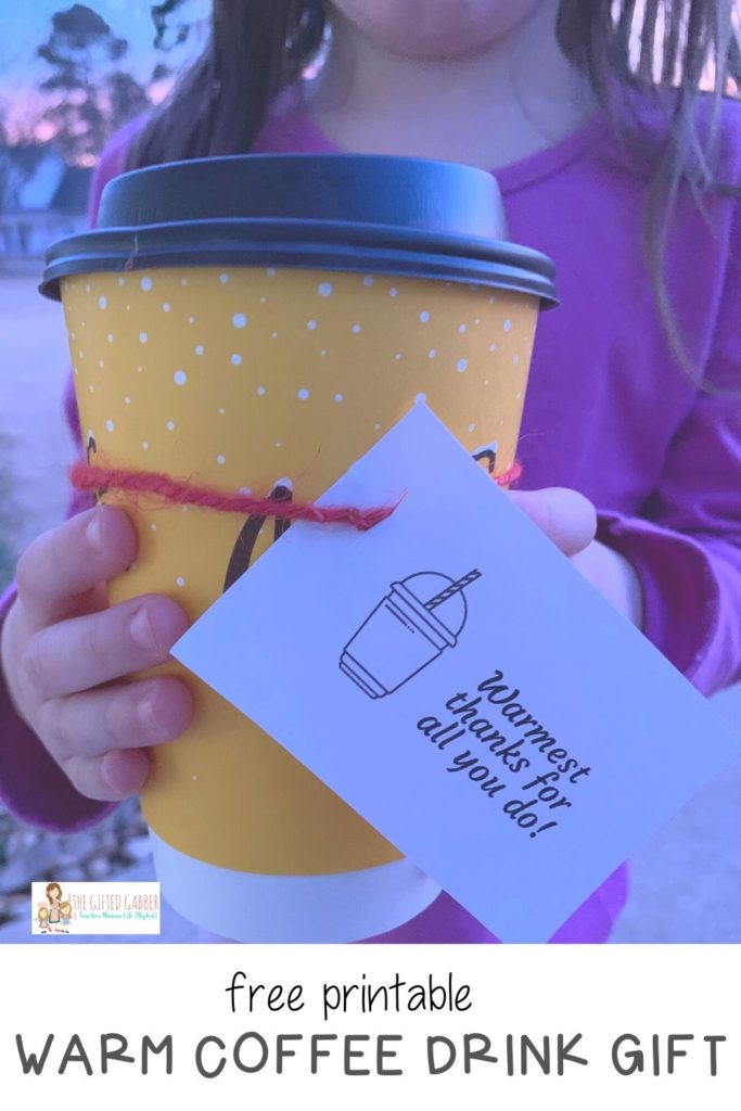 little girl holds a warm coffee gift drink for her teacher with a thank you tag