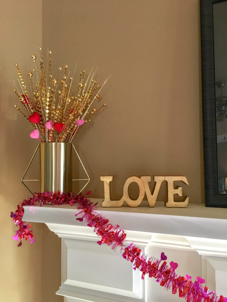 brass vase with heart picks and brass LOVE sign on mantle as part of Valentine's home tour