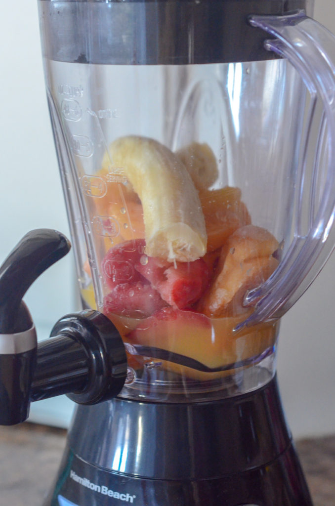 strawberry banana smoothie with orange juice ingredients in a blender 
