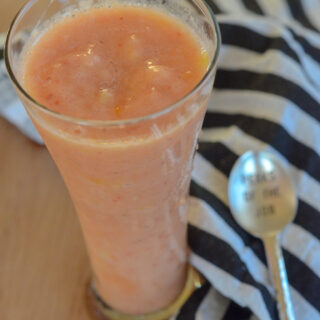 dairy free smoothies with orange juice with striped napkin and spoon