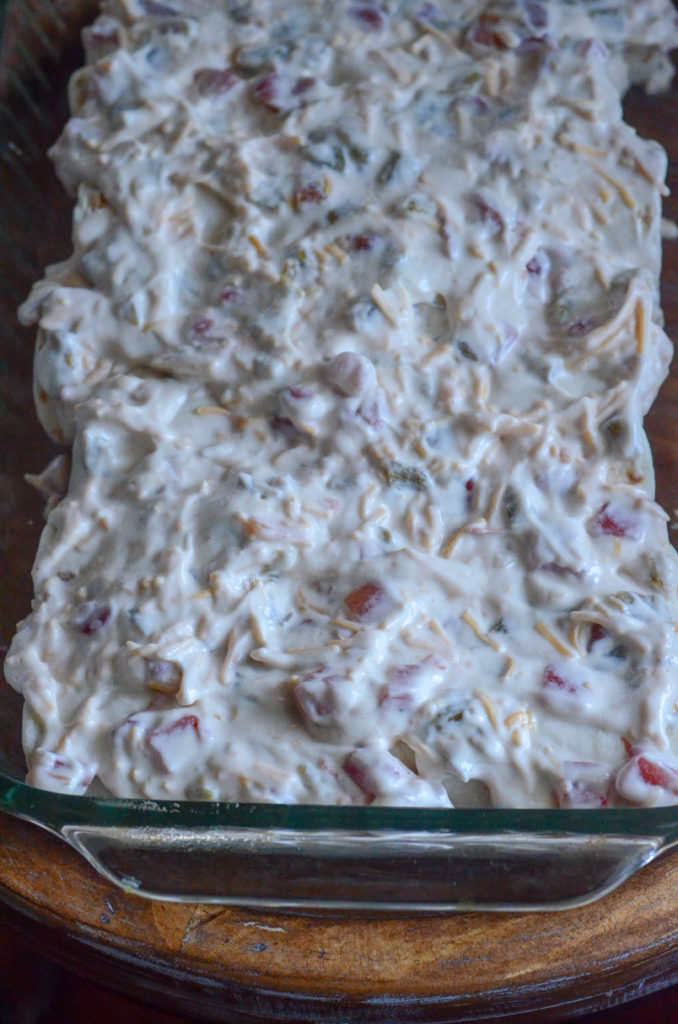 chicken enchiladas covered in sour cream sauce before going in oven 