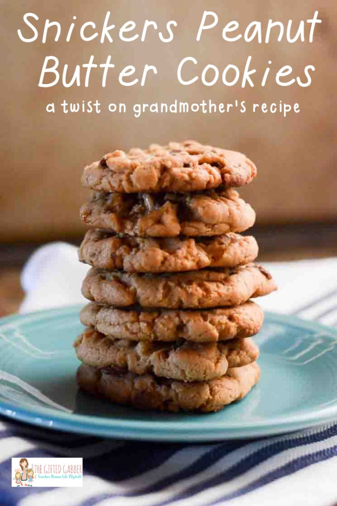 Tall stack of chocolate peanut butter cookies with Snickers on teal plate with text
