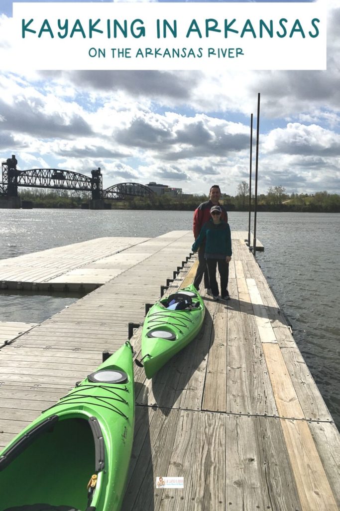 couple stands on deck with kayaks before going kayaking in Arkansas
