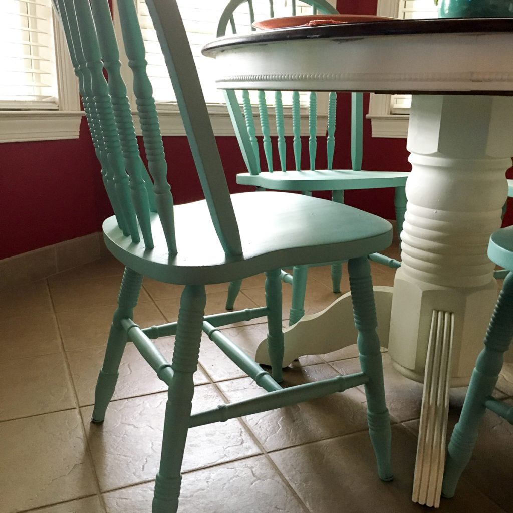 This turquoise and white kitchen table brings a little DIY inspiration for that teal or turquoise kitchen table you have been thinking of! This family downsized from a larger rectangular table to a smaller round table to go along with some interior design changes. This small painted table and chairs combine three different paint colors for a modern vibe that lends itself well to fun and casual decor. #kitchen #table #diy #turquoise #paint 