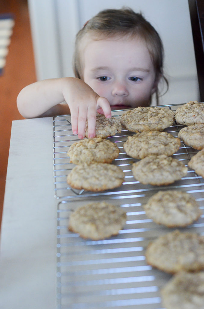 little girl reaches for a cookie 