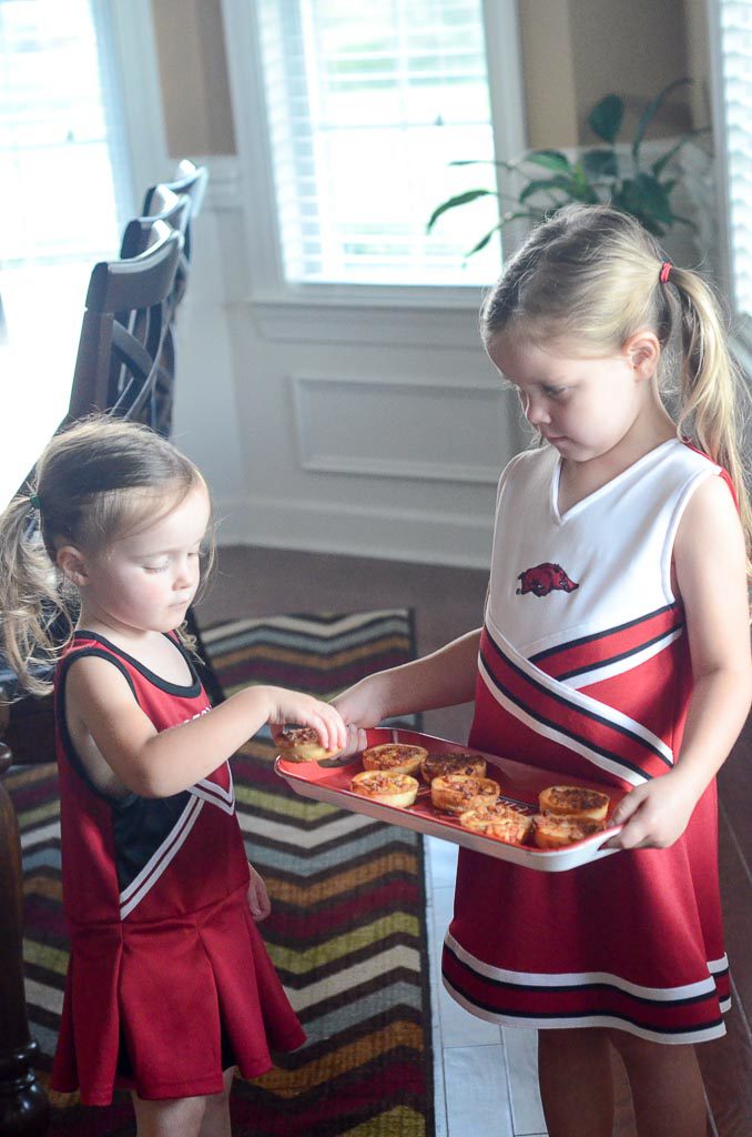 Little girls with pizzas on tray 