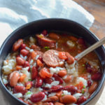 red beans and rice with canned beans in black bowl with white napkin