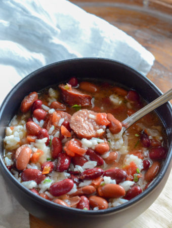 red beans and rice with canned beans in black bowl with white napkin